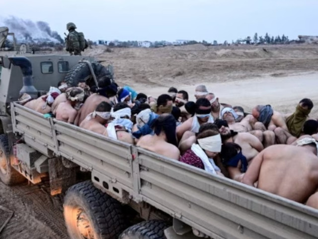 israeli soldiers stand by a truck packed with shirtless palestinian detainees amid the ongoing conflict between israel and the palestinian islamist group hamas in the gaza strip december 8 2023 photo reuters